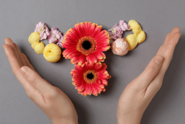 γυναικεία χέρια με λουλούδια σε σχήμα μήτρας